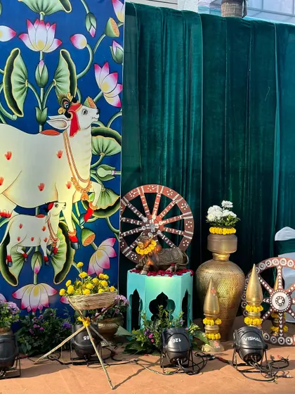A beautiful corner from our Vrindavan theme, featuring a Pichwai-style painting of a cow and calf, along with traditional brass pots and other decor elements.