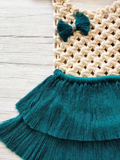 A detailed shot of the bodice and bow of the macrame dress.