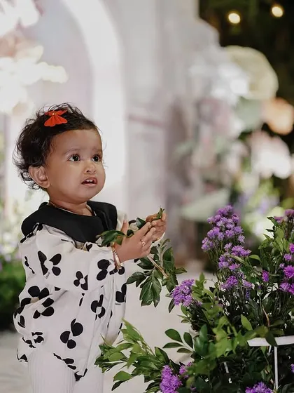 A candid shot of the birthday girl interacting with the floral decorations. I use high-quality, realistic flowers and props to create a sensory-rich environment for children to explore.