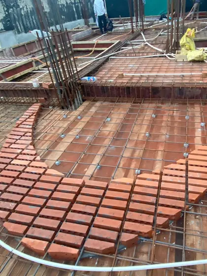 Preparing for a concrete pour at the Waterfall project in Noida. This image shows the brick infills being laid out in an elliptical design before the reinforcement and concrete are added, a key step in creating the exposed brick slab.