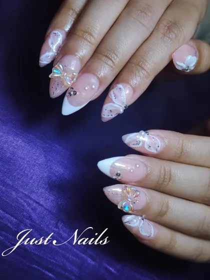 Showcasing my love for intricate, hand-painted details. These stiletto nail extensions feature delicate 3D butterfly and bow embellishments, white swirl patterns, and scattered gems over a glittery nude base with a French tip.