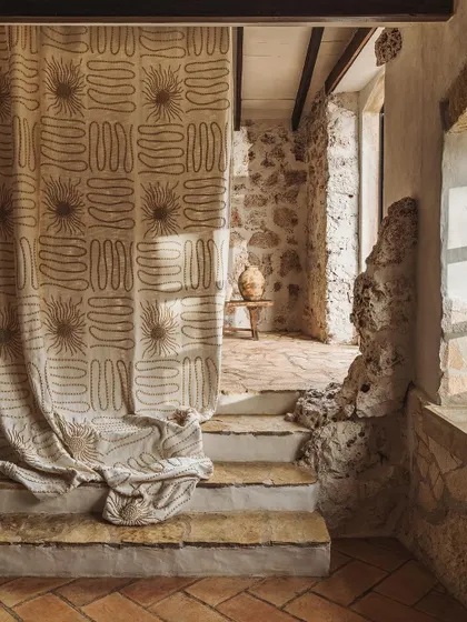 A detailed shot of our 'Perpétuel Soleil' fabric from the Paloma Baléares collection. The hand-embroidered wooden beads create a captivating, artisanal pattern on a natural linen base, perfect for creating one-of-a-kind drapery.