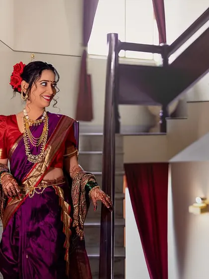 A joyful, candid shot of the bride on the staircase, her smile lighting up the entire frame.