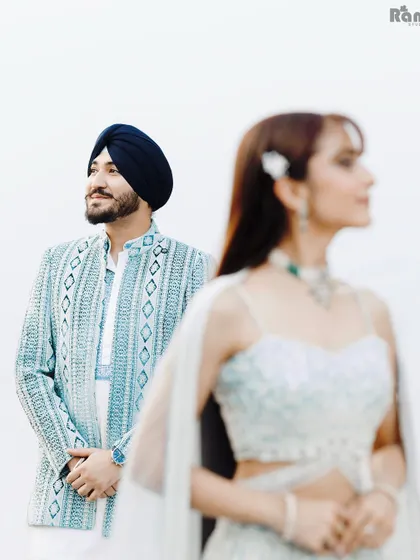 An artistic shot using focus to create depth. With the groom in sharp focus and the bride softly blurred in the foreground, this portrait tells a story of admiration and love.
