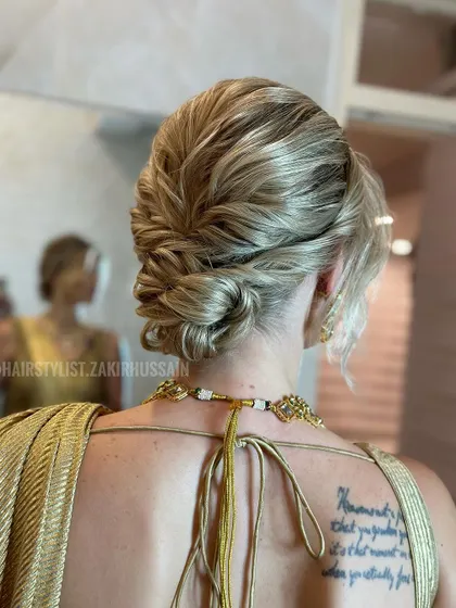 Another angle of the blonde updo, demonstrating how the style looks from the side and how it complements the client's back tattoo.