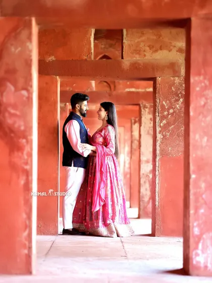 A romantic pose framed by the repeating archways of the Taj Mahal's adjoining structures, creating a sense of depth and history.