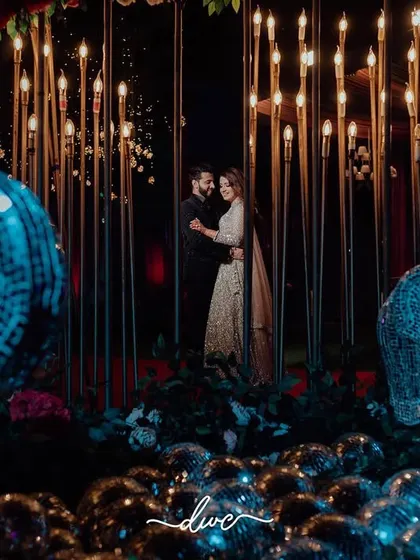 A grand and dramatic portrait of the couple at their engagement, surrounded by a creative installation of disco balls and lights.