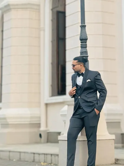 A confident and stylish pose. This three-piece suit is perfect for the groom who wants a classic yet modern look for his special day.