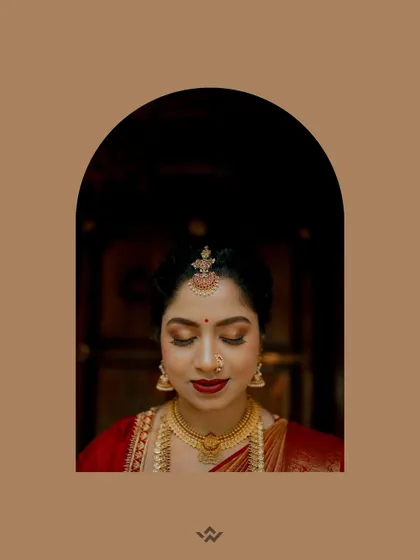 An artistic portrait of the bride, her face framed by an arch, highlighting her serene expression and beautiful makeup.