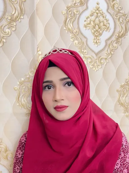 A simple and elegant hijab style for a party. The makeup is clean with defined eyes and a red lip, and the look is completed with a delicate tiara.
