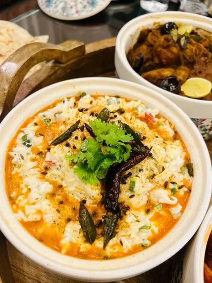 A close-up of our tempered Curd Rice, a comforting and classic South Indian dish. It's the perfect accompaniment to our spicy Chettinad and Ghee Roast preparations.