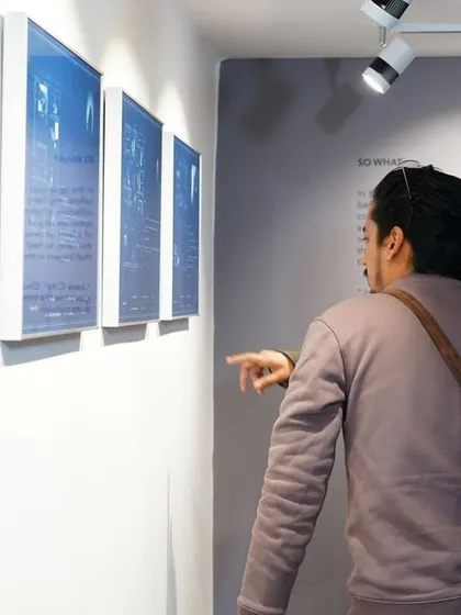 A couple admiring a series of cyanotype prints on display. The distinct blue of the cyanotype process always draws attention and sparks conversation.