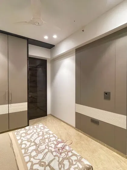 This shot showcases the custom wardrobes and their two-tone design. The seamless, handle-less finish contributes to the room's minimalist and sophisticated feel.