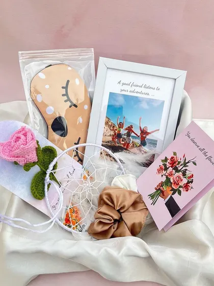 This pamper hamper is perfect for a best friend. It features a personalized photo frame, a cute eye mask, a crochet rose, a dream catcher, and scrunchies, all curated to make her feel loved.