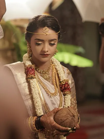 A candid moment of the bride during her Muhurtham ceremony. The makeup is subtle and elegant, ensuring she looks like the best version of herself.