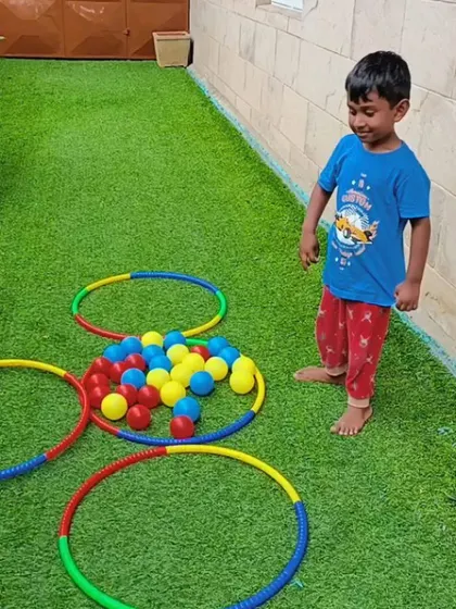 A happy camper stands proudly after completing the color sorting game. Learning through play is at the heart of our philosophy.