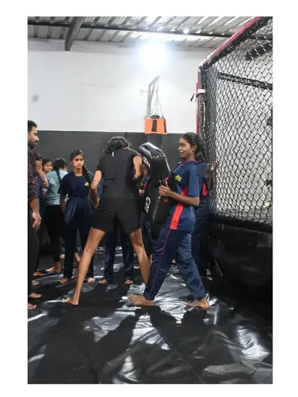 A student practices striking a pad held by a partner. This drill helps build power and accuracy in a safe, controlled manner.