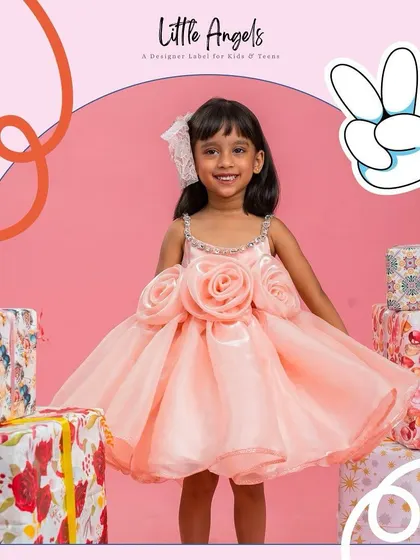 A happy girl surrounded by presents in our peach "Flower Dress".