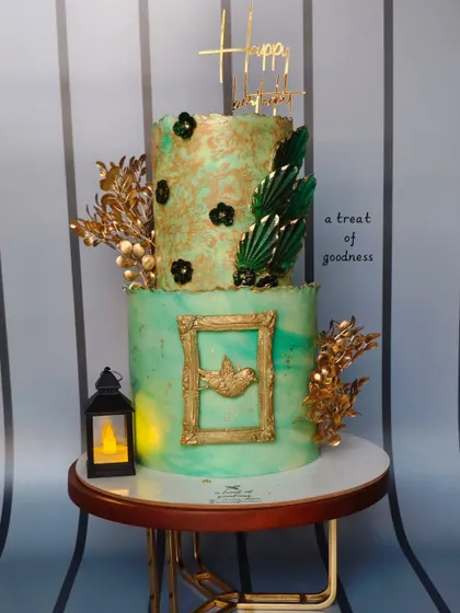 A full view of the bird-lover's cake, complete with a lit lantern to add to the ambiance. The combination of different textures and gold accents makes this a truly special, art-inspired piece.
