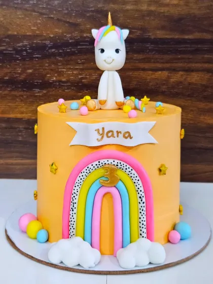 A unicorn and rainbow cake for Yara's 3rd birthday. This chocolate truffle cake has a fun, modern design with a black and white dotted rainbow.