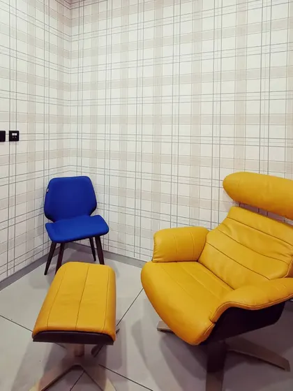 A quiet corner with modern, comfortable seating, including a classic yellow lounge chair and ottoman. These spaces are designed for individual focus or quiet conversation.