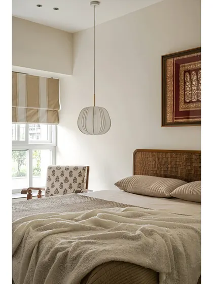 Sometimes, all a space needs is a good piece of furniture and a bit of nostalgia. This bedroom corner in 'Kayu' features a comfortable bed, a unique pendant light, and a framed piece of traditional textile art, adding a personal and sentimental touch.