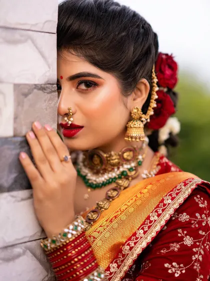 A creative portrait that highlights the fresh, glowy makeup. The red lip is the star of the show, adding a touch of classic glamour to her traditional look.