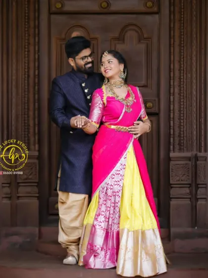 A classic portrait of the couple. Her look features traditional jewelry and makeup with a bold lip, perfectly matching the bright colours of her South Indian style outfit.