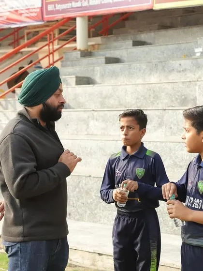 A coach provides a mid-match briefing to two young players. These tactical discussions are vital for developing game awareness and the ability to adapt to changing situations on the field.