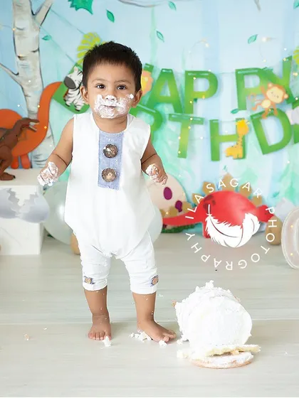 Standing tall and proud after his cake smash adventure. This dinosaur and jungle themed setup is perfect for a little explorer's first birthday.