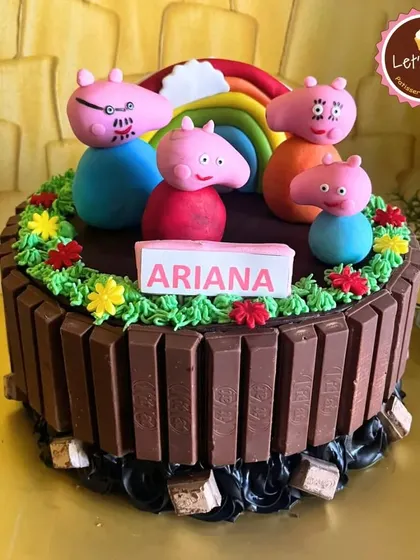 I love creating cakes based on beloved children's characters, like this Peppa Pig cake. It features a KitKat border and handcrafted fondant figures of the whole family, making it a delightful and delicious centerpiece for a young child's party.