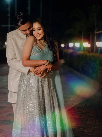 A romantic portrait of the couple at night, with a creative rainbow light flare adding a touch of magic.