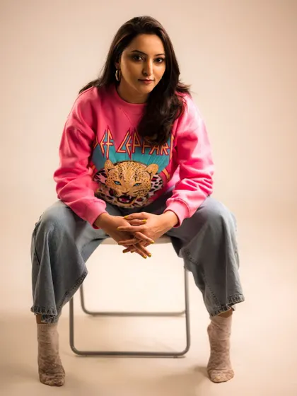 A full-frontal pose that is confident and direct. The graphic sweatshirt makes a bold statement.