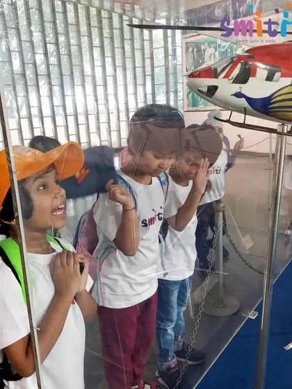 Children peer at a model helicopter, their curiosity piqued by the intricate details.