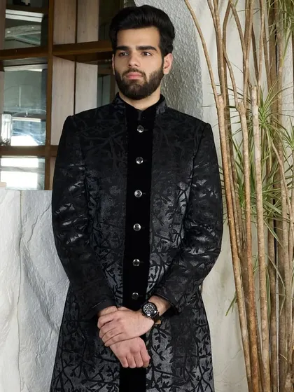 A full-length view of the black patterned kurta. The subtle sheen of the fabric and the velvet placket create a look of deep, luxurious elegance.