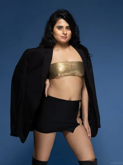 A model in a gold top and black blazer, creating a chic and powerful look.