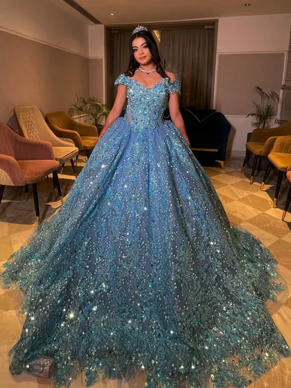 Our gorgeous client looking like a true princess in our sparkling turquoise ball gown. The off-shoulder design and voluminous skirt create a stunning silhouette, perfect for making a grand entrance at her engagement party.