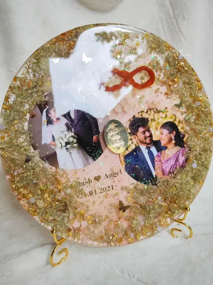 The round wedding keepsake frame displayed on a metal stand, perfect for table decor.