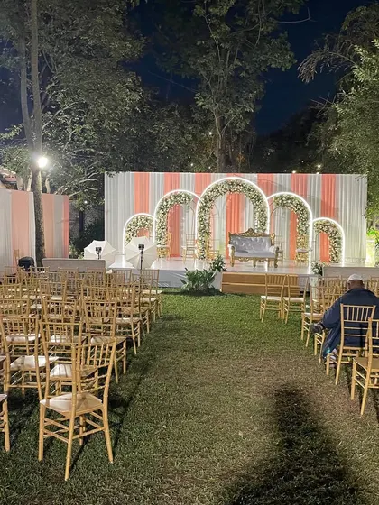 The setup for an outdoor evening Nikah, with neatly arranged chairs leading to a beautifully decorated stage. This demonstrates a simple yet elegant approach to wedding planning.