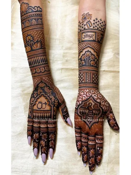 A sweet and personal design featuring engagement rings and the bride's name 'Ankita'. The arms are decorated with swans and the tree of life.