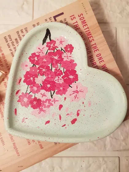 The mint green cherry blossom heart tray, empty to show the full detail of the hand-painted design. Each petal is placed with care.