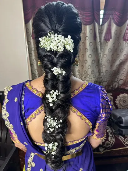 A voluminous pull-through braid decorated with clusters of baby's breath, perfect for a reception or party.