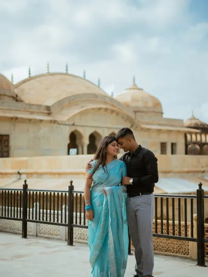 A tender moment with the fort's domes in the background. The cloudy sky adds a soft, diffused light, perfect for capturing the emotion in this candid couple photo session.