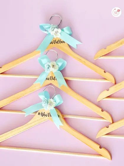 Personalized wooden hangers with the wedding hashtag and a decorative bow. A lovely and practical gift for the bride, groom, or the entire bridal party.