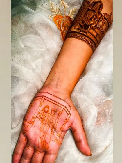 The initial sketch of a couple's portrait on the palm, showing the first step in creating a personalized mehandi.