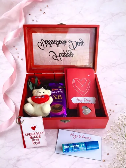 A little red box filled with hugs and sweet surprises. This hamper includes a personalized message on the lid, a teddy bear, Dairy Milk Silk, and other thoughtful love notes.