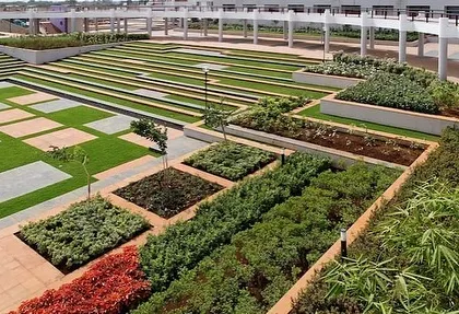 A closer view of the tiered planters and geometric grass sections in the podium garden. This type of landscape architecture requires precise execution.