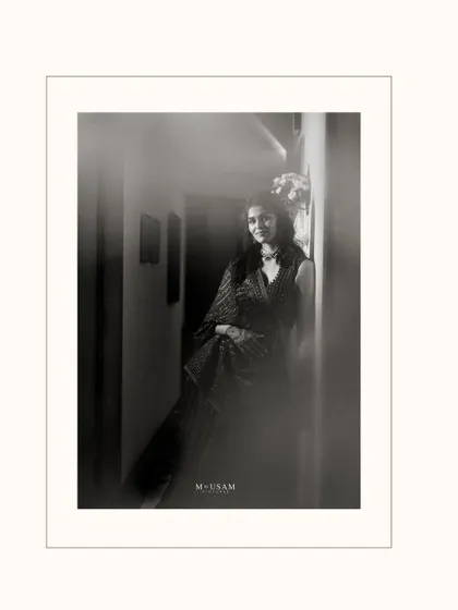 A dreamy, black and white portrait of the bride during her Mehendi. The soft focus and play of light create a timeless, ethereal feel, capturing her quiet joy and anticipation.