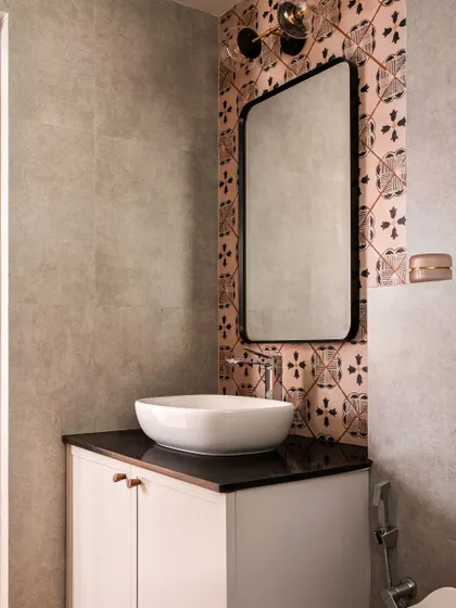 The attached bathroom for the parents' room features a playful mix of pink and black patterned tiles, adding a touch of personality while complementing the bedroom's color scheme.