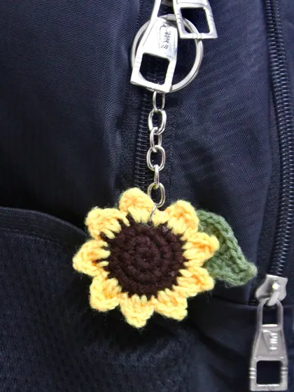 Here is the sunflower keychain being used as a bag charm on a backpack. It's a great way to personalize your belongings.